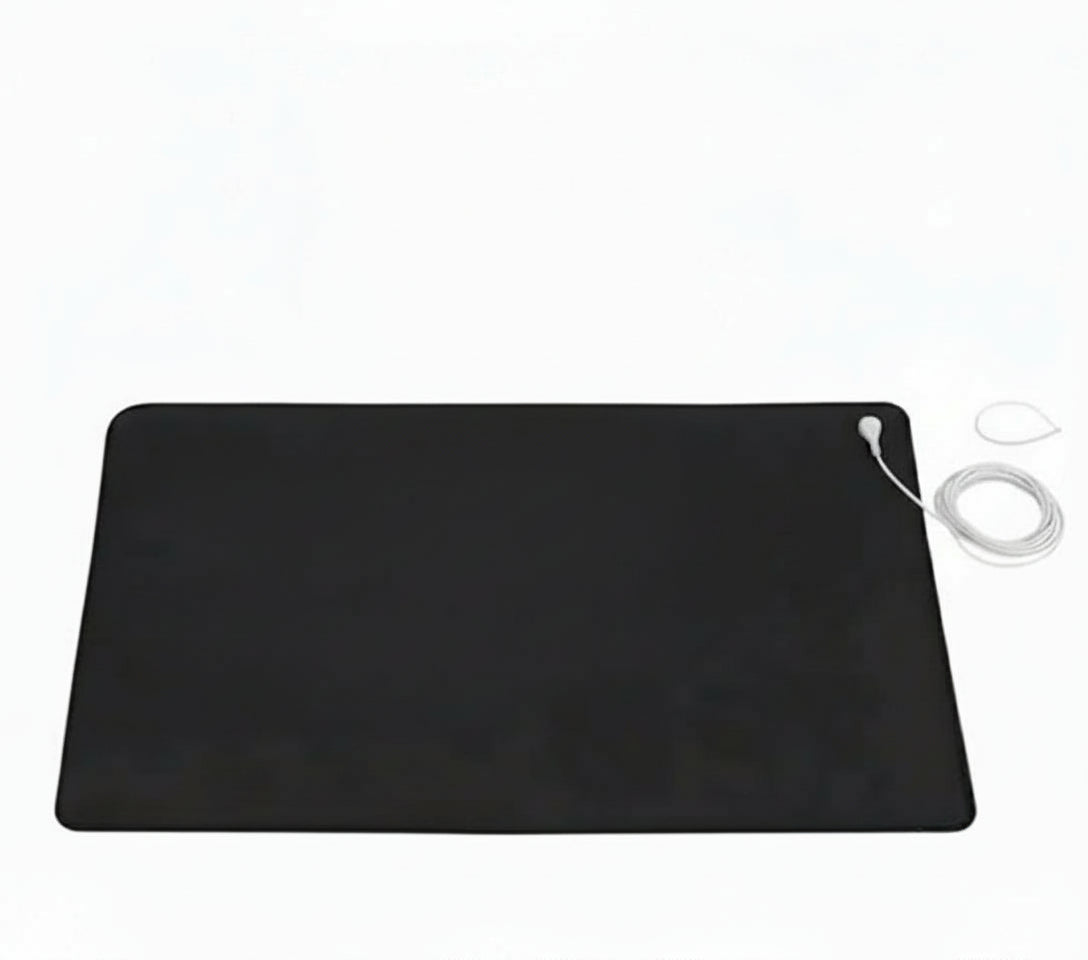 Black heating pad with a white cord on a white background