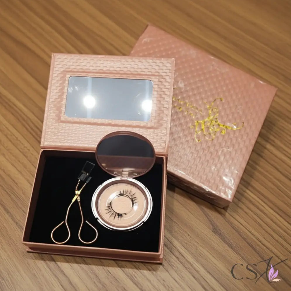 Eyelash in a decorative box with a mirror on a wooden surface, featuring the brand 'CSX'.