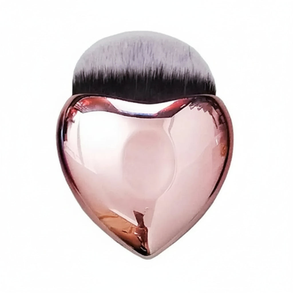 Makeup brush with heart-shaped pink handle on a white background